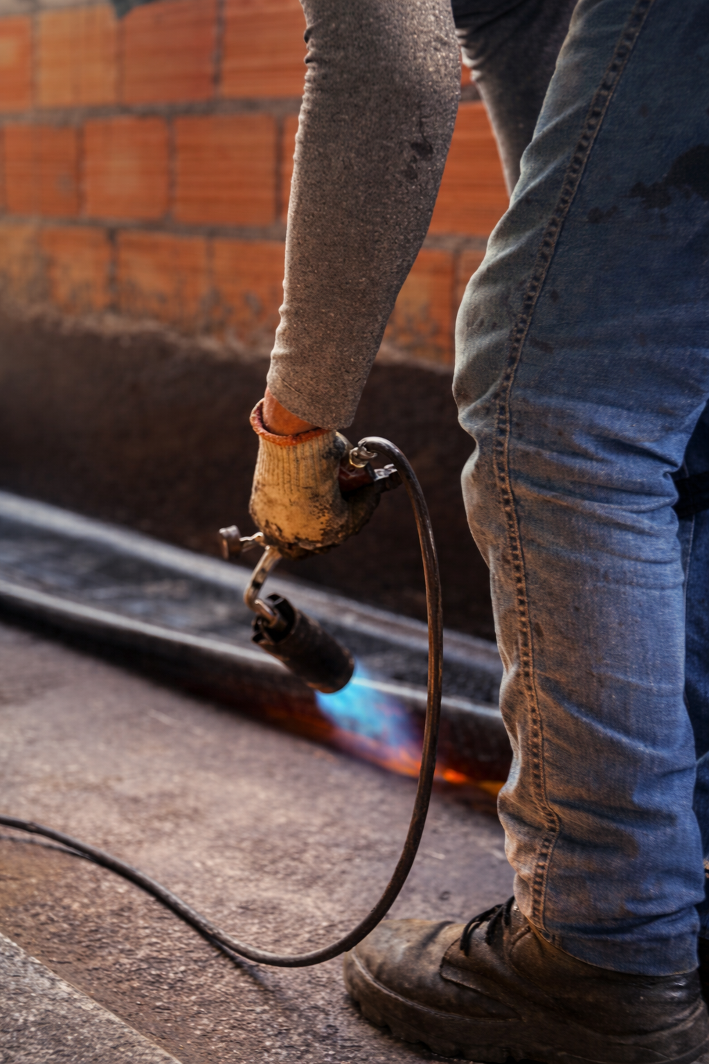 Profissional ImperC aplicando manta asfáltica com maçarico